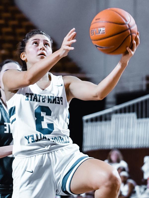 Female basketball player jumping with ball